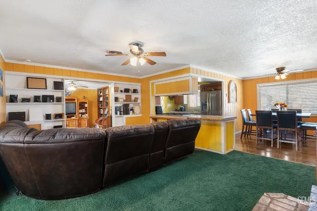 a living room with furniture and a open kitchen view