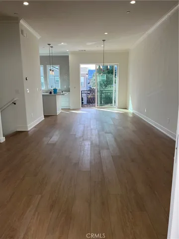 an empty room with wooden floor and outdoor view
