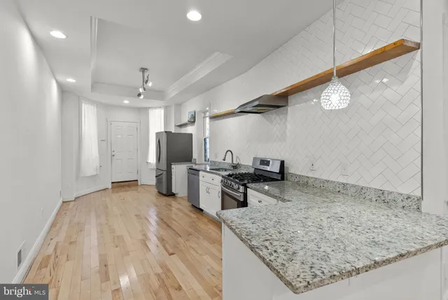 a kitchen with stainless steel appliances granite countertop a sink refrigerator and cabinets