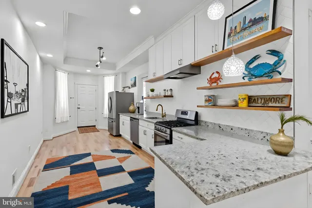 a kitchen with stainless steel appliances granite countertop a sink a stove and a wooden cabinets