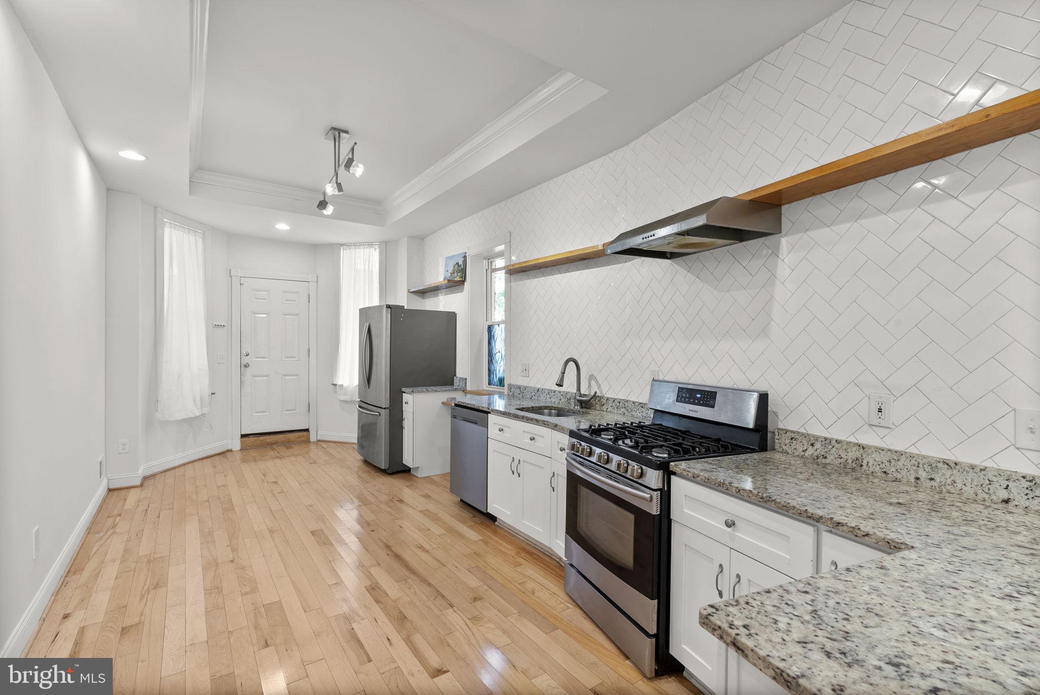 722 Lennox Street Baltimore, MD 21217 - Photo 16 of 52 a kitchen with stainless steel appliances granite countertop a stove and a refrigerator
