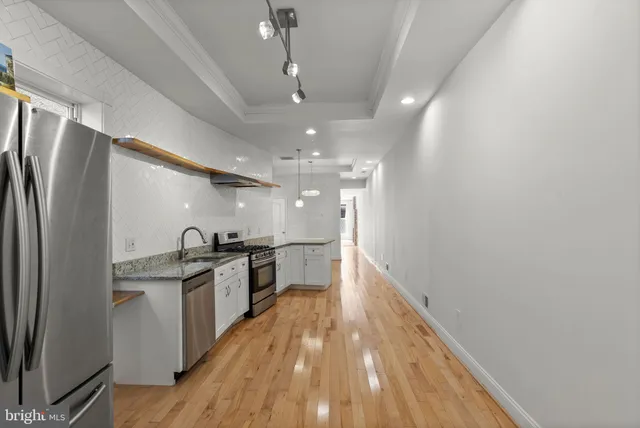 a view of a kitchen with a sink and wooden floor