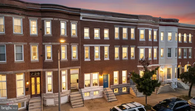 a front view of a building with lots of green space