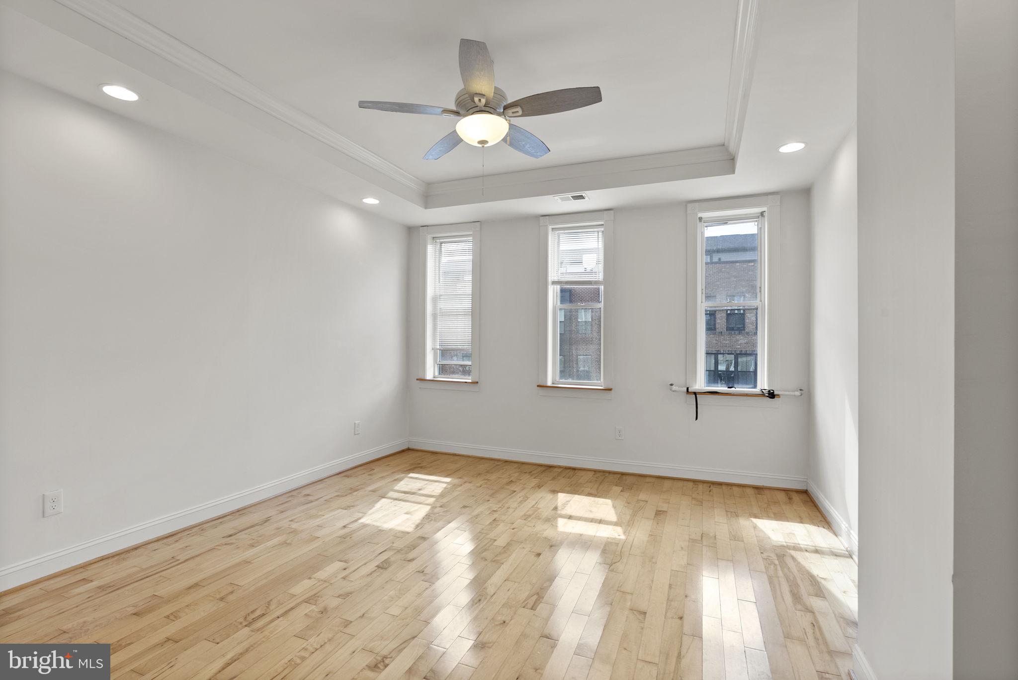 722 Lennox Street Baltimore, MD 21217 - Photo 21 of 52 an empty room with windows and ceiling fan