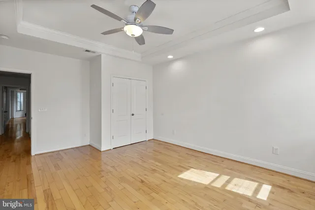 an empty room with a ceiling fan and a window