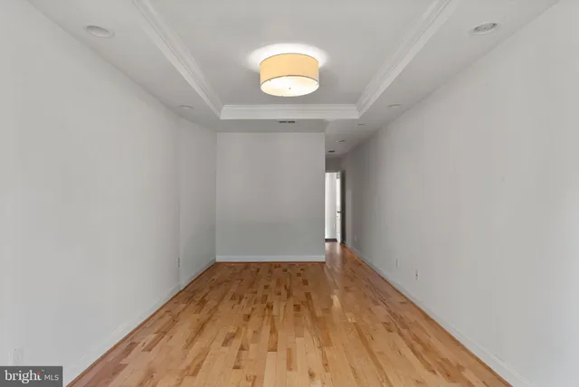 a view of a room with wooden floor and a window