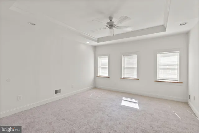 an empty room with windows and fan