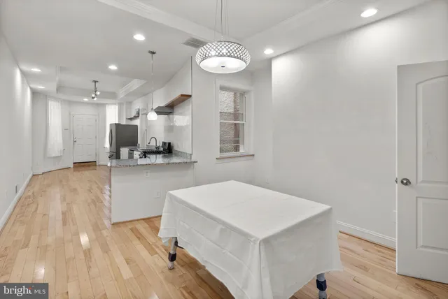 a kitchen with a refrigerator a sink and dishwasher with wooden floor