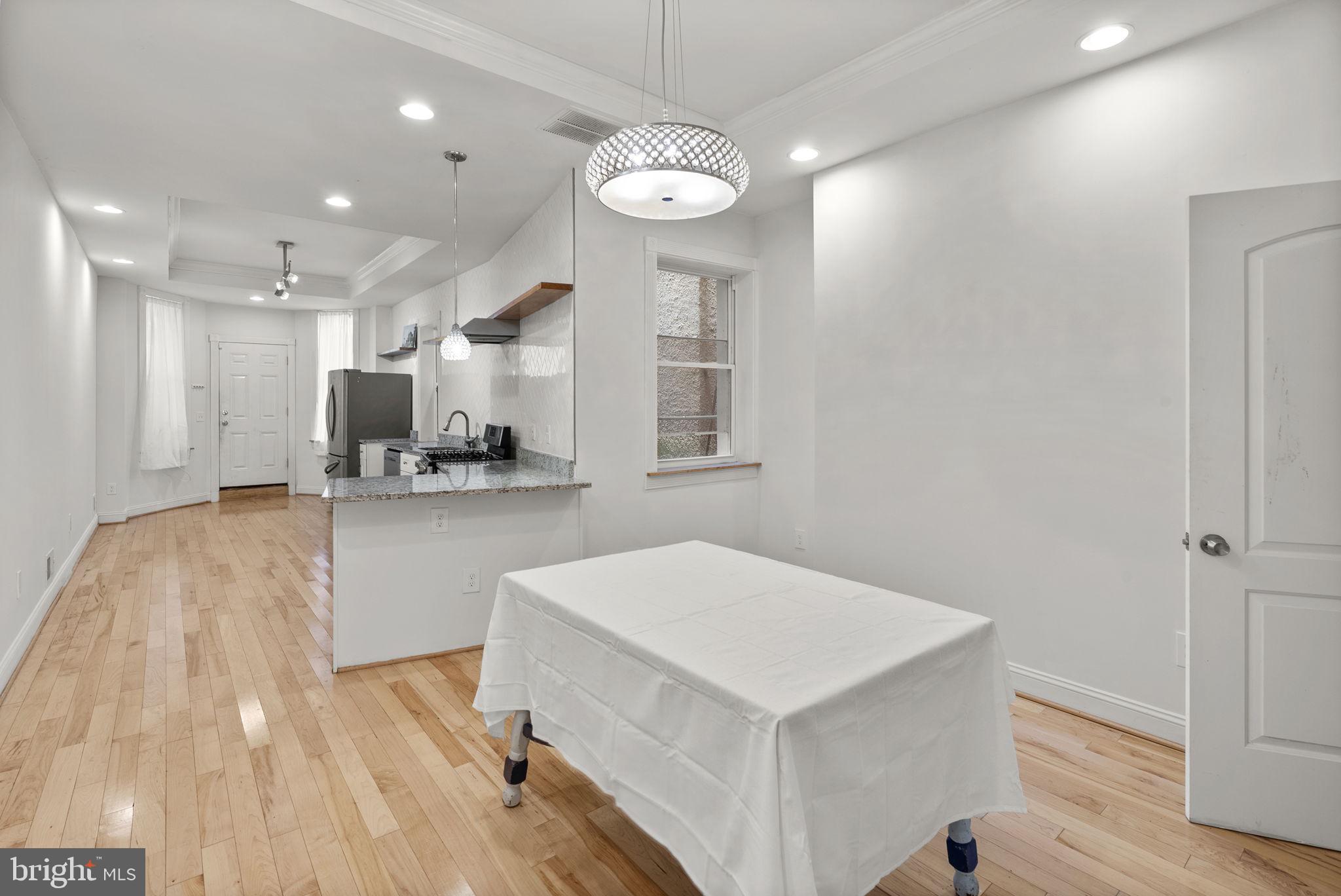 722 Lennox Street Baltimore, MD 21217 - Photo 10 of 52 a kitchen with a refrigerator a sink and dishwasher with wooden floor