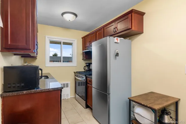 a kitchen with stainless steel appliances granite countertop a refrigerator a stove top oven a sink and dishwasher