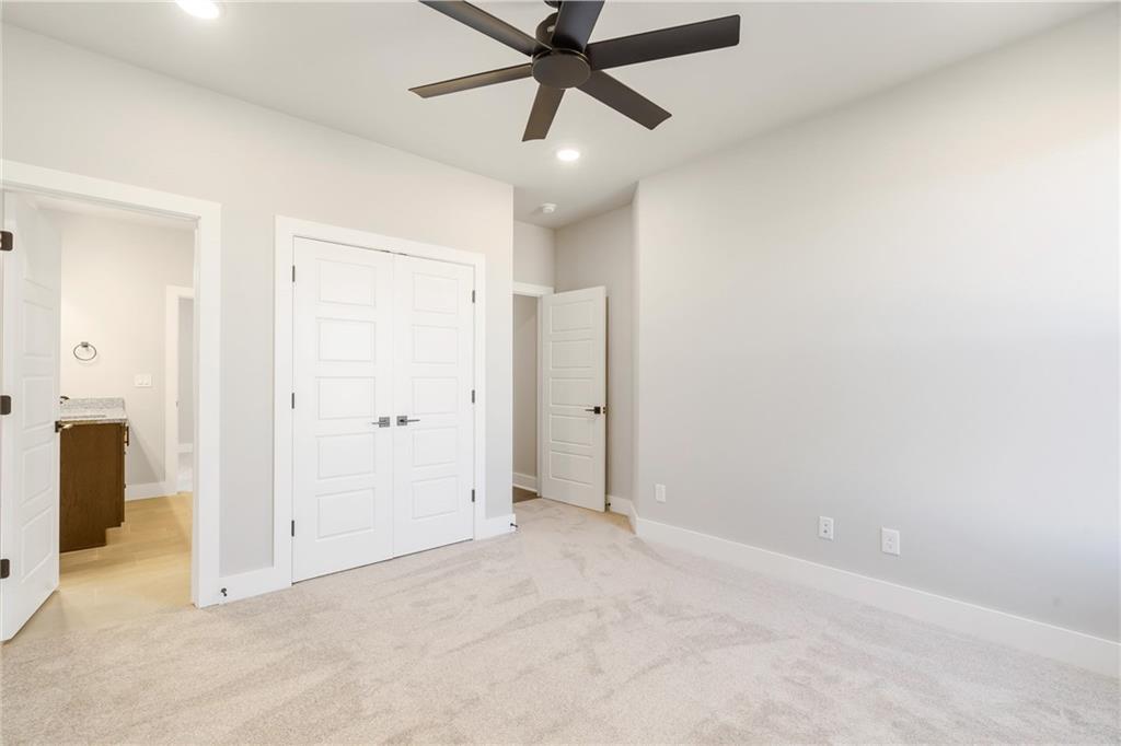 1910 Peacock Road Centerton, AR 72719 - Photo 18 of 29 Light-toned carpeting, white trim, recessed lighting, and a dark-toned ceiling fan