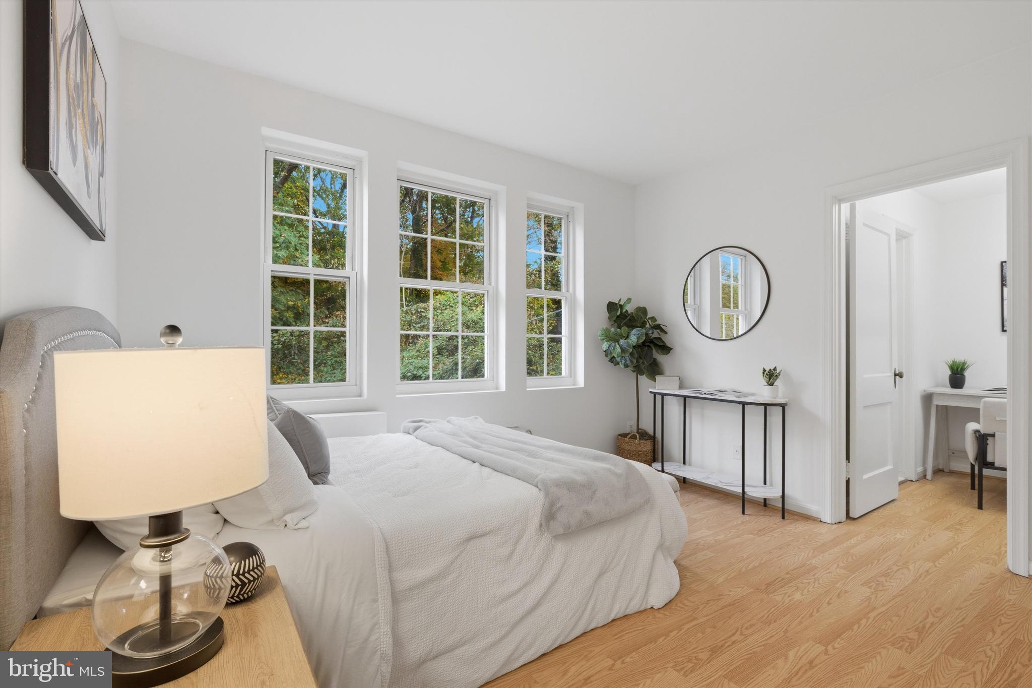 1909 North Rhodes Street, Unit 25 Arlington, VA 22201 - Photo 7 of 16 a bedroom with a bed a mirror and a large window