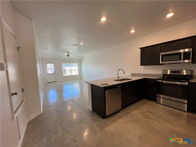 a kitchen with a sink and stove top oven