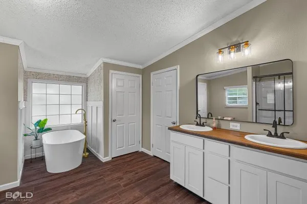 a bathroom with a granite countertop sink a toilet a mirror and shower