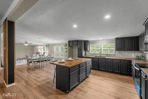 a kitchen with stainless steel appliances granite countertop sink stove top oven and refrigerator