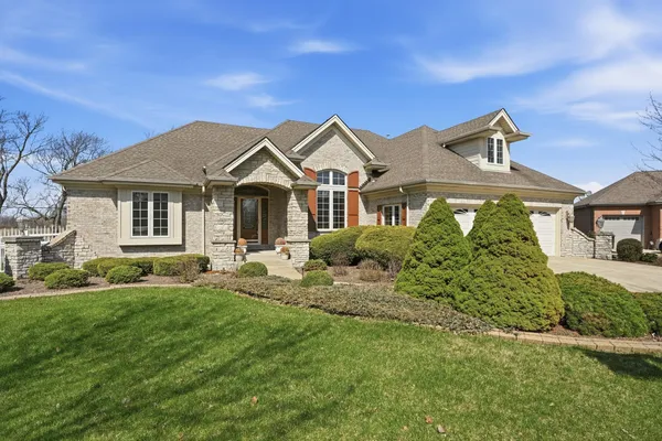 a front view of a house with a garden and plants