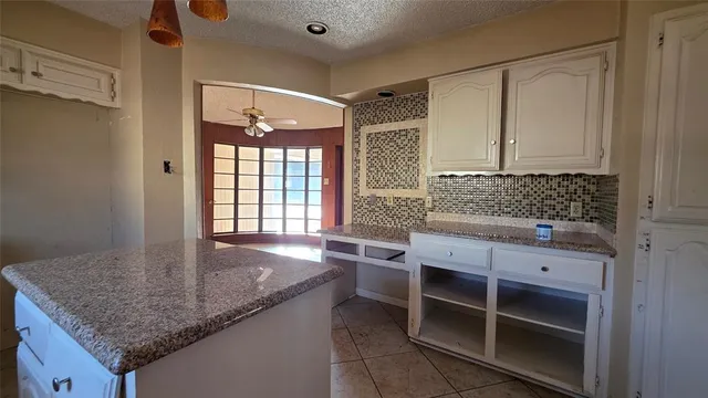 a kitchen with granite countertop a sink and cabinets