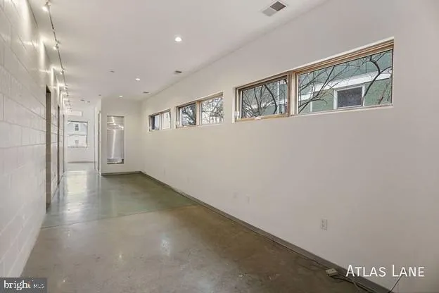 a view of an empty room with stairs and a window