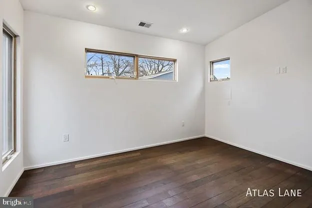 a view of an empty room with wooden floor