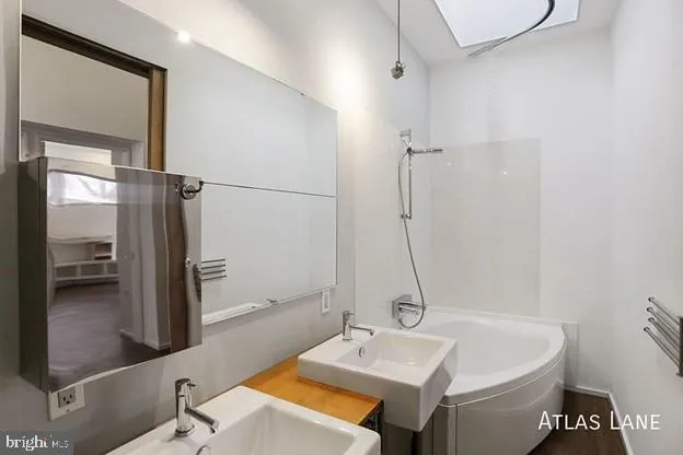 a bathroom with a tub sink and mirror