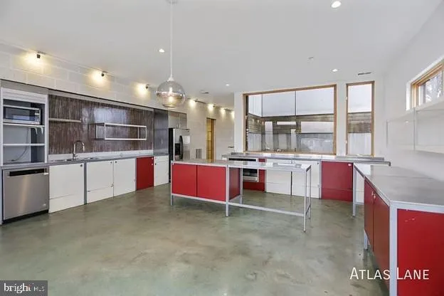 a large kitchen with stainless steel appliances kitchen island granite countertop a stove and a refrigerator