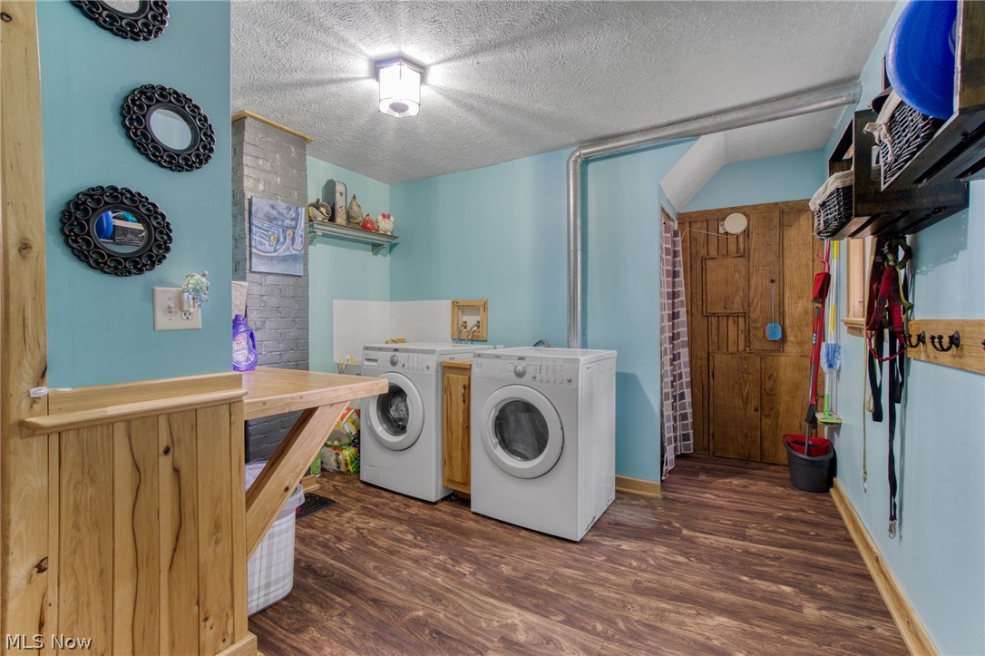 15221 Thompson Road Thompson, OH 44086 - Photo 11 of 31 Laundry area featuring dark hardwood / wood-style flooring, a textured ceiling, and independent washer and dryer