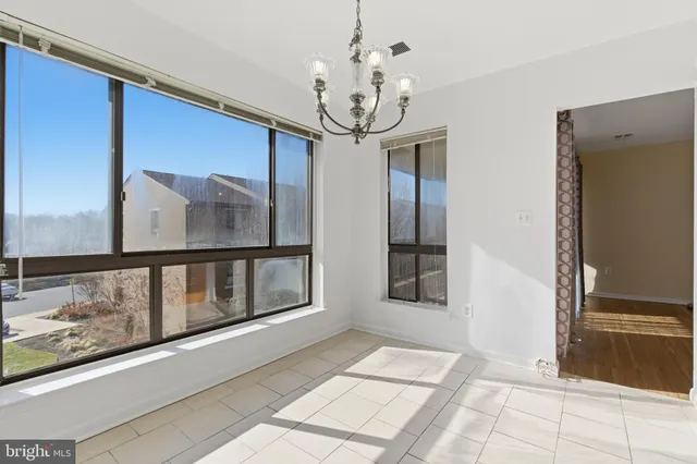 a view of a hallway with windows and chandelier