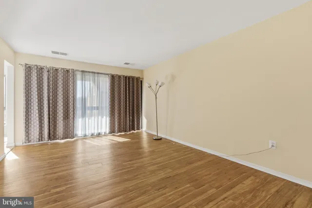 a view of an empty room with wooden floor
