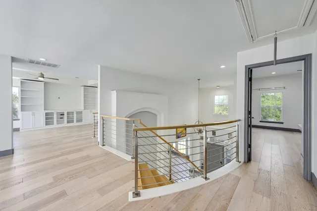 a view of a hallway with wooden floor and stairs