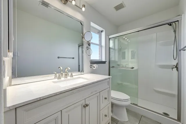 a bathroom with a sink a toilet and shower