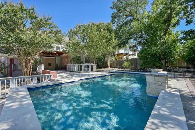 a swimming pool with outdoor seating and yard