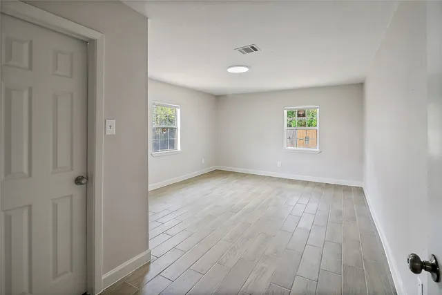 an empty room with windows and closet