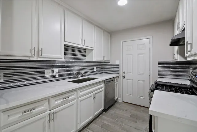 a kitchen with granite countertop white cabinets and appliances