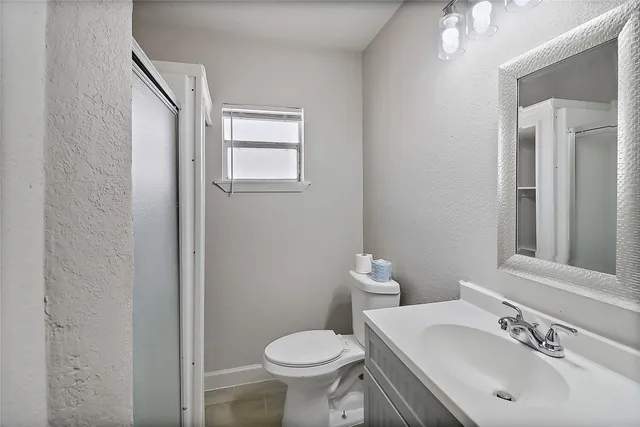 a bathroom with a sink toilet and mirror