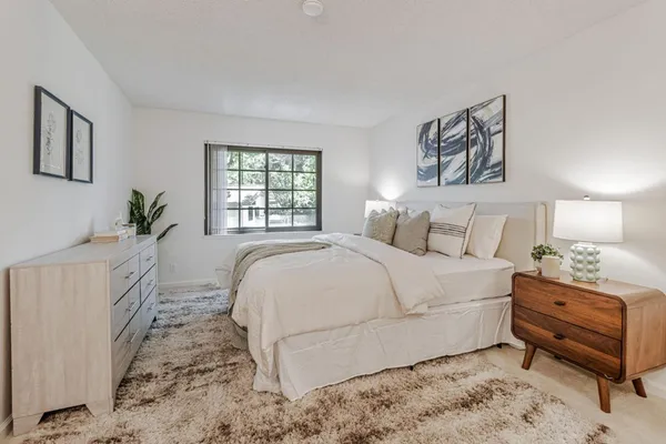 a bedroom with a large bed and a window