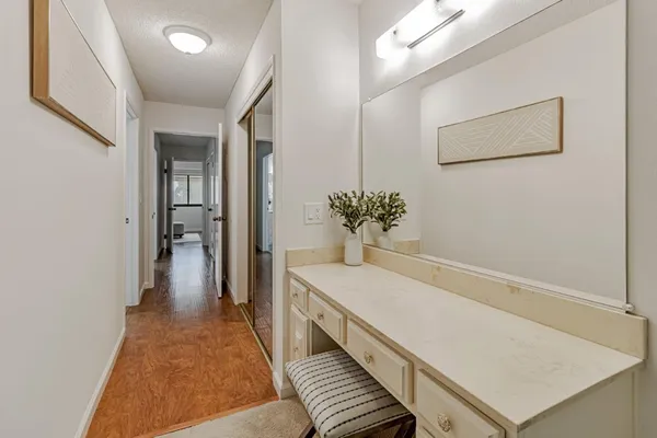 a hallway with painting on the wall and a potted plant