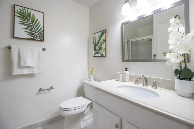 a bathroom with a toilet a sink and mirror