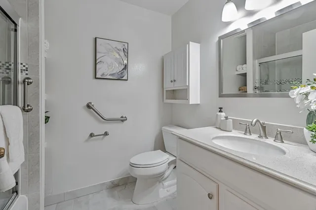 a bathroom with a granite countertop toilet sink and a mirror
