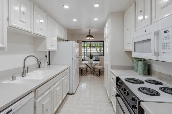 a kitchen with sink a stove and a refrigerator