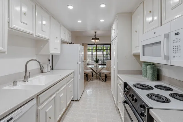 a kitchen with sink a stove and a refrigerator
