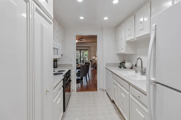 a kitchen with kitchen island granite countertop a sink and cabinets