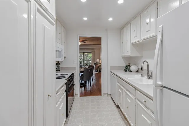 a kitchen with kitchen island granite countertop a sink and cabinets
