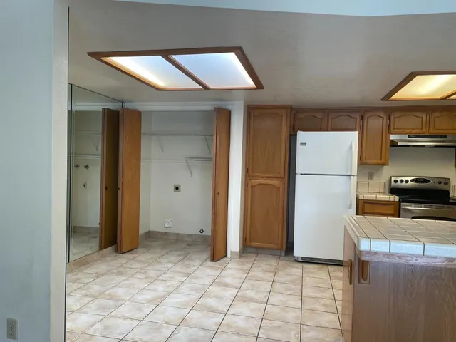 a kitchen with stainless steel appliances granite countertop a refrigerator and a stove top oven