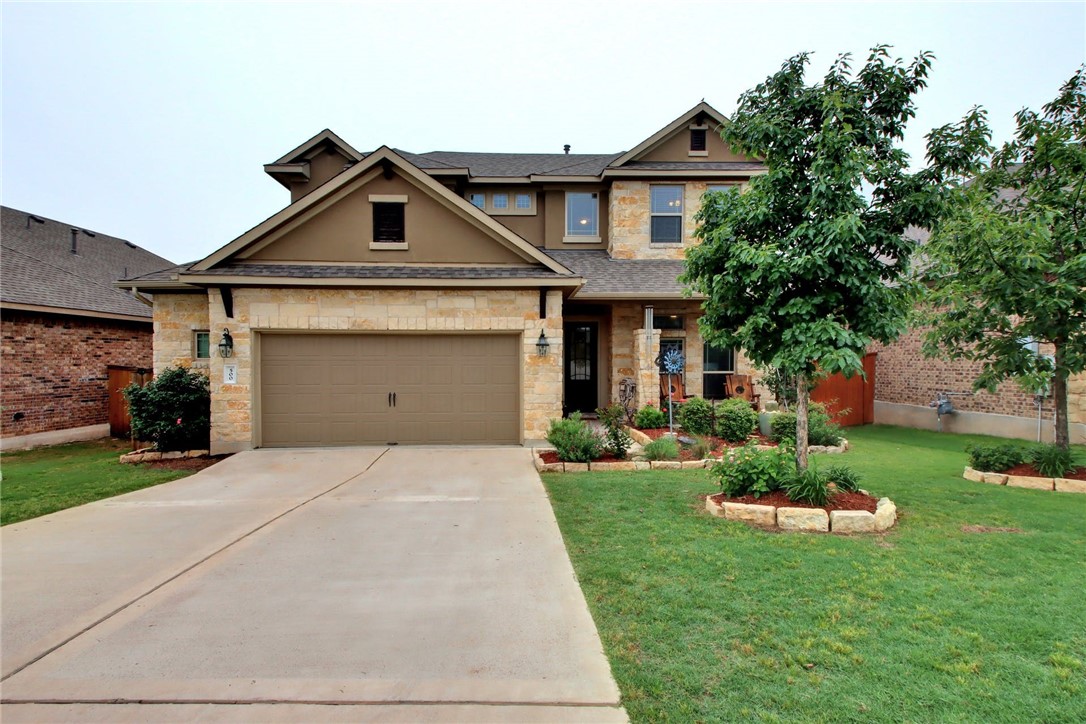 a front view of a house with a yard and a garage