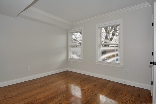 84 Maple Street, Unit 2 Boston, MA 02132 - Photo 11 of 15 a view of an empty room with wooden floor and a window