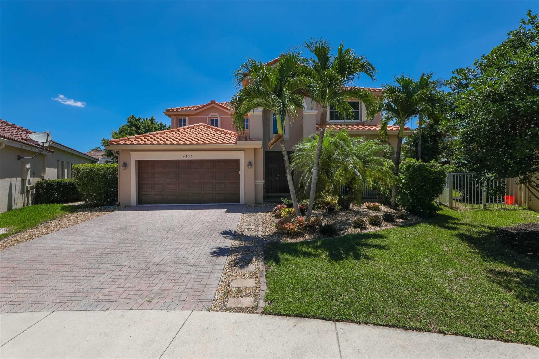 4452 Stone Ridge Way Weston, FL 33331 - Photo 3 of 65 a front view of a house with a garden and plants