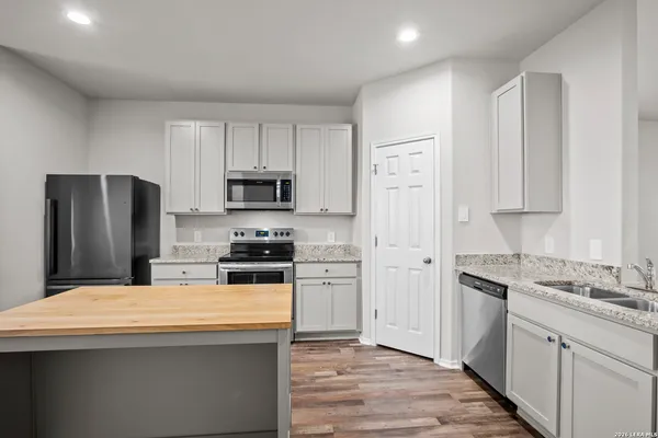 a kitchen with stainless steel appliances granite countertop a refrigerator and a stove top oven
