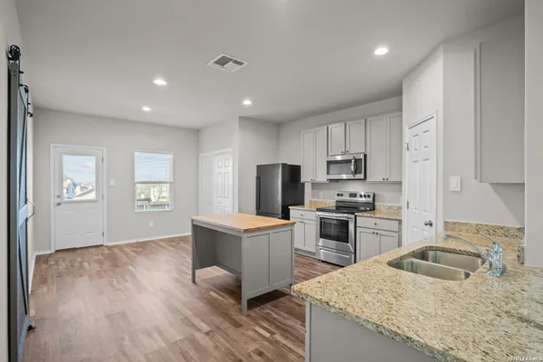 a kitchen with a stove a sink and a refrigerator