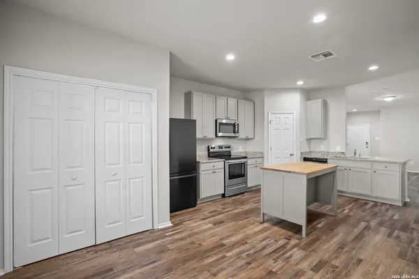a kitchen with a refrigerator and white cabinets