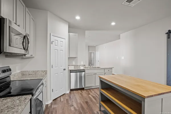 a kitchen with stainless steel appliances a stove microwave and refrigerator
